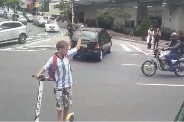 Criança controla o trânsito com apito e patinete