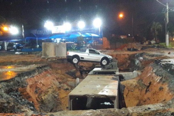 Chuva arrasta sinalização de obra e carro cai em buraco em Taubaté, SP