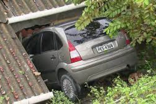 Carro quebra muro, despenca de ladeira e cai dentro de casa