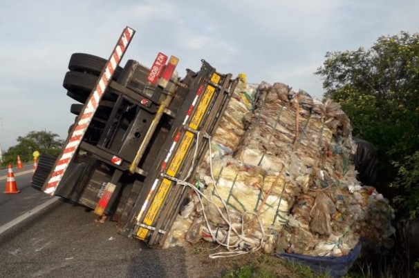 Caminhão carregado de plástico tomba em rodovia