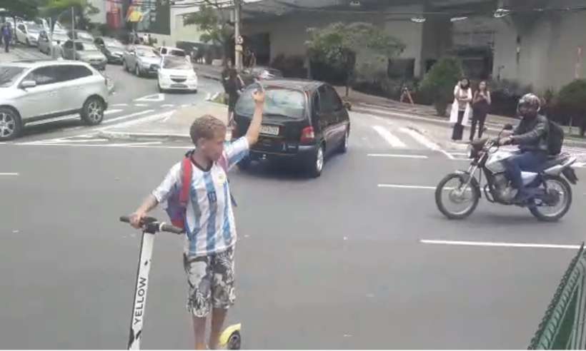 Criança controla o trânsito com apito e patinete