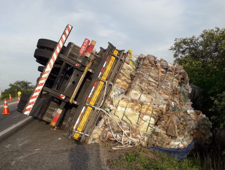 Caminhão carregado de plástico tomba em rodovia
